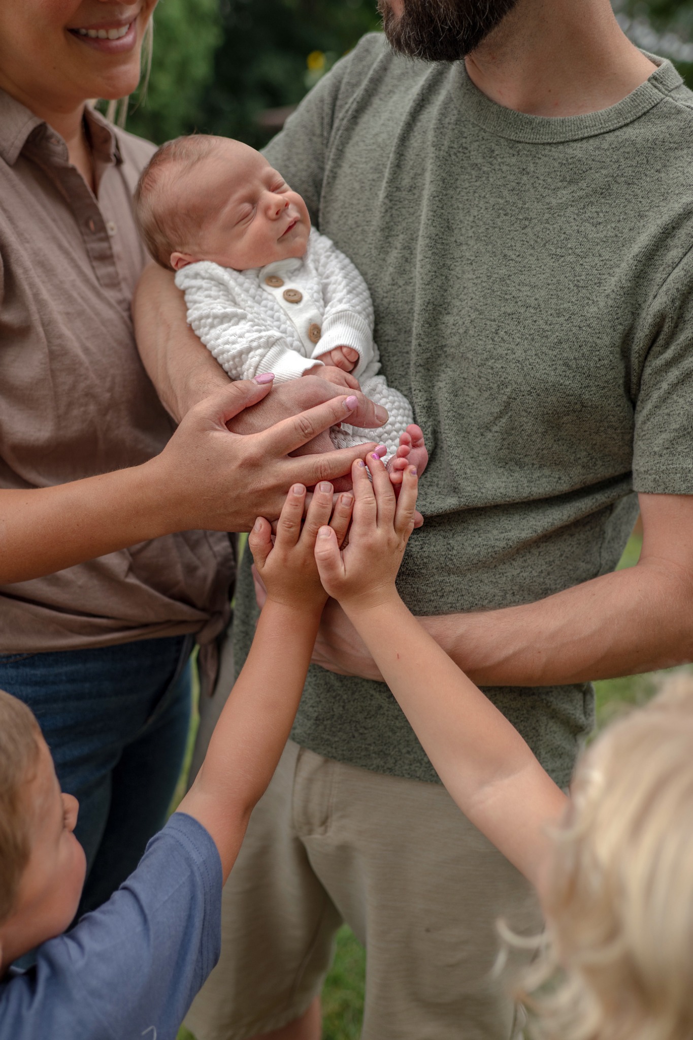 grand rapids newborn family photography parents holding baby outdoors