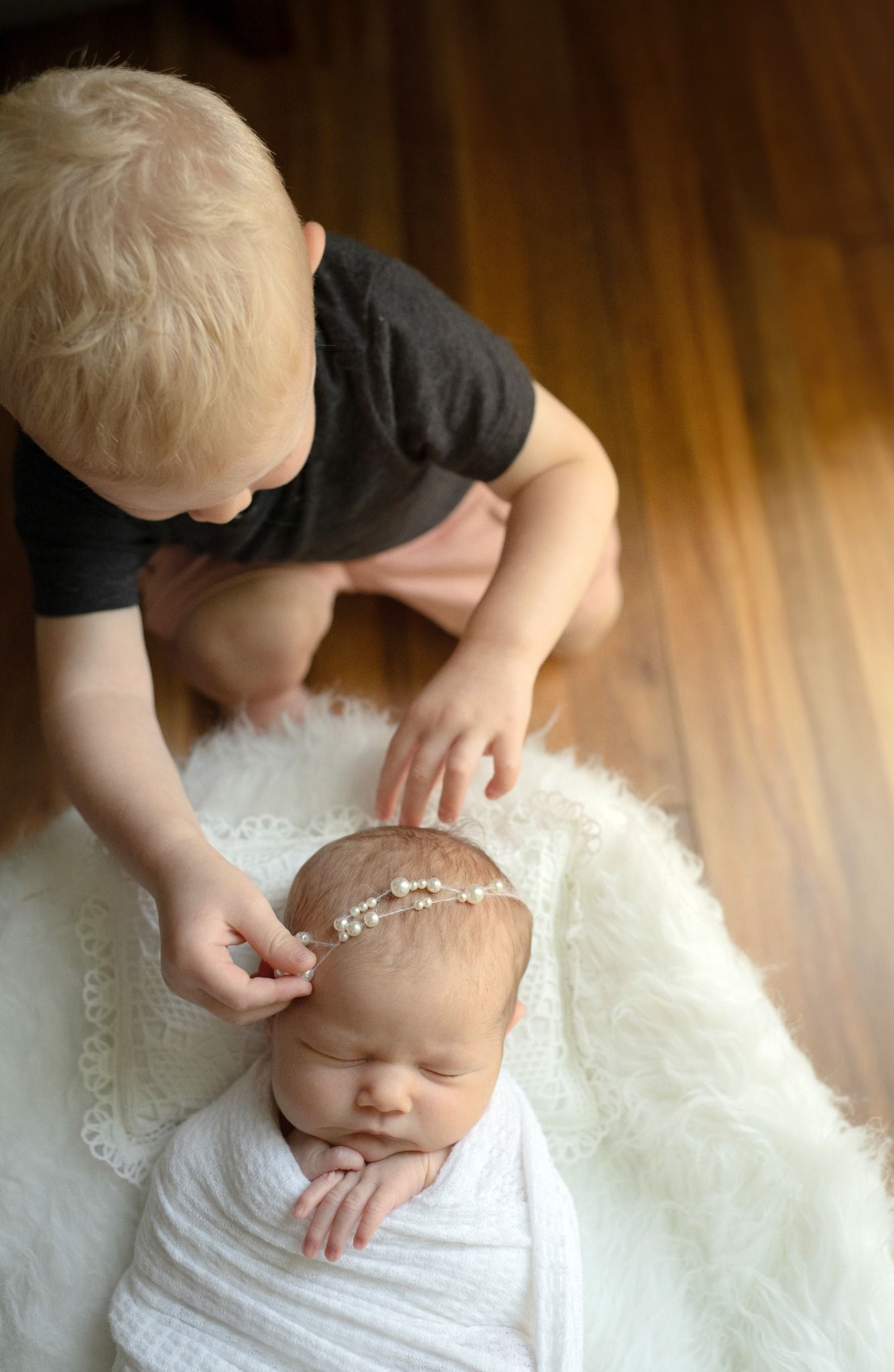 grand rapids newborn sibling adjusting baby headband