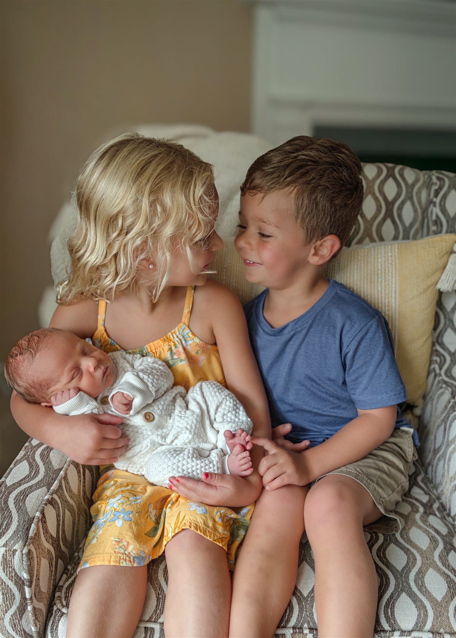 grand rapids newborn sibling holding new baby chair