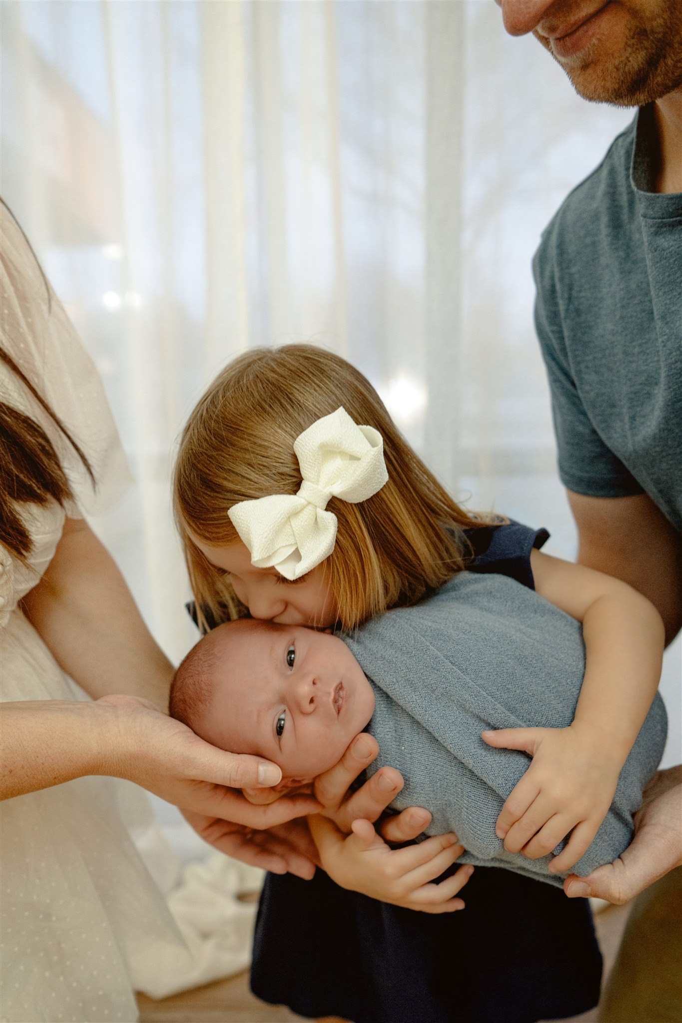grand rapids newborn sibling kissing baby